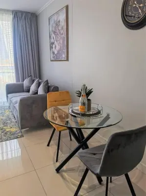 a living room with a glass table and a couch at Executive Suite at Ellipse Waterfall Midrand in Midrand
