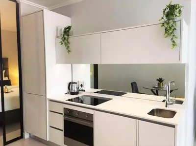 a kitchen with white cabinets and a sink at Executive Suite at Ellipse Waterfall Midrand in Midrand