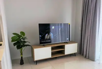 a flat screen tv sitting on top of a cabinet at Executive Suite at Ellipse Waterfall Midrand in Midrand