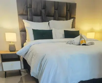 a bedroom with a large white bed with a large headboard at Executive Suite at Ellipse Waterfall Midrand in Midrand