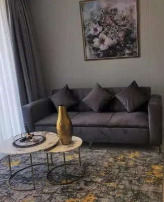 a living room with a couch and a table at Executive Suite at Ellipse Waterfall Midrand in Midrand