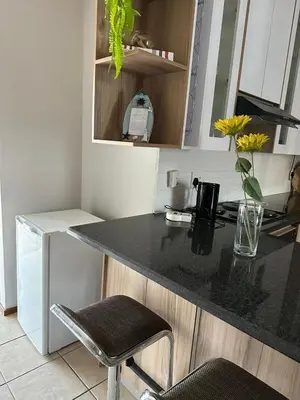 a kitchen with a counter with a black counter top at Air bnb 204 in Midrand