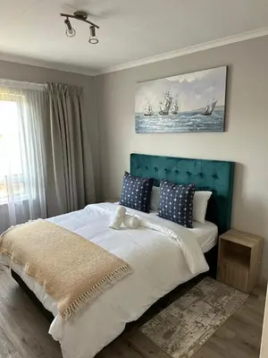 a bedroom with a large bed with a blue headboard at Air bnb 204 in Midrand