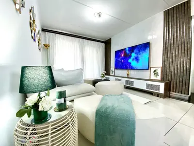 a living room with a couch and a tv at Siena Sun Luxury Suites 5 in Midrand
