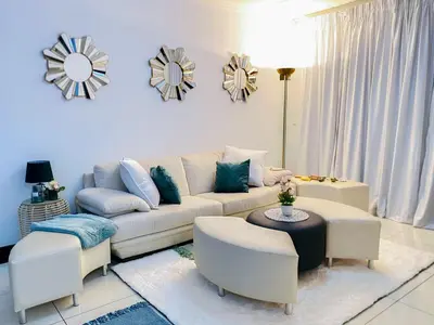 a living room with a couch and a table and chairs at Siena Sun Luxury Suites 5 in Midrand