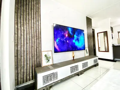 a living room with a flat screen tv on a wall at Siena Sun Luxury Suites 5 in Midrand