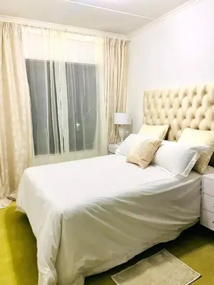a bedroom with a large white bed with a large headboard at Midrand Siena Sun Luxury Suites 3 with water reserve in Midrand