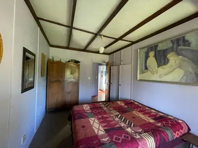a bedroom with a bed and a painting on the wall at Thathe Dam Lodge in Vhutandabos