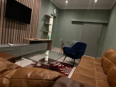 a living room with a couch and a glass table at Silverton Private Apartment in Pretoria