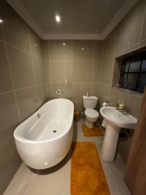 a bathroom with a tub and a toilet and a sink at Silverton Private Apartment in Pretoria