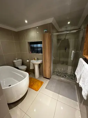 a bathroom with a tub and a shower and a toilet at Silverton Private Apartment in Pretoria