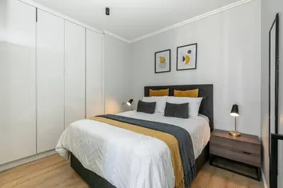 a bedroom with a large bed with white walls at iNqaba @Ellipse Waterfall in Midrand