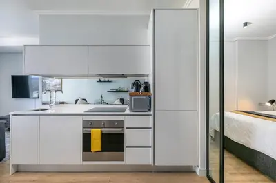 a white kitchen with a sink and a microwave at iNqaba @Ellipse Waterfall in Midrand