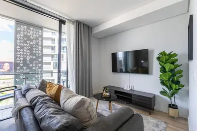 a living room with a couch and a large window at iNqaba @Ellipse Waterfall in Midrand