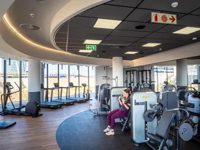 a woman sitting on a treadmill in a gym at Executive Suite at Ellipse in Waterfall Midrand in Midrand