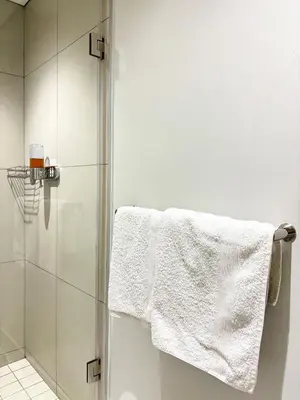 a bathroom with a shower with a white towel at Executive Suite at Ellipse in Waterfall Midrand in Midrand