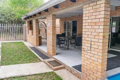 a brick patio with a table and chairs at Ingwe House in Marloth Park