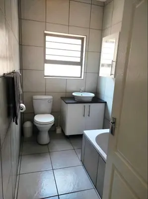 a bathroom with a toilet and a sink and a tub at Ingwe House in Marloth Park