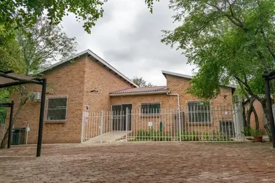 a brick building with gates and a fence at Ingwe House in Marloth Park
