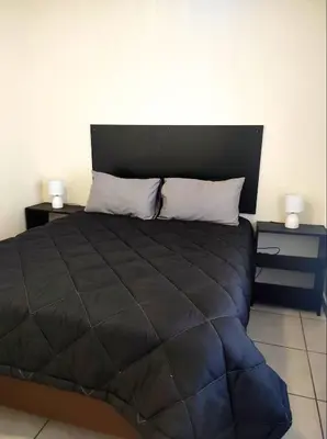 a bedroom with a large bed with two night stands at Ingwe House in Marloth Park