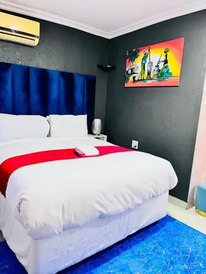 a bedroom with a large white bed in a room at Executive Galaxy Guest House Nkowankowa Extension 2 in Tzaneen