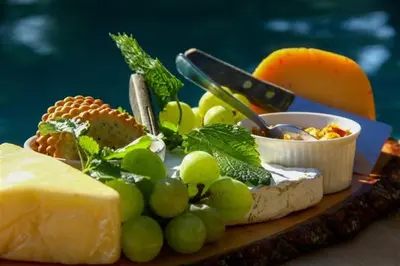 a plate of cheese and grapes and other food on a table at NDZUTI BUSH CAMP in Balule Game Reserve