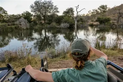 a person riding in a boat on a river at NDZUTI BUSH CAMP in Balule Game Reserve