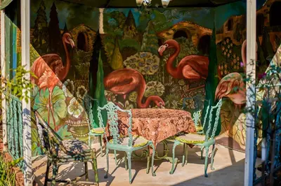 a table and chairs in front of a mural of flamingos at Duck and Dine in Pretoria