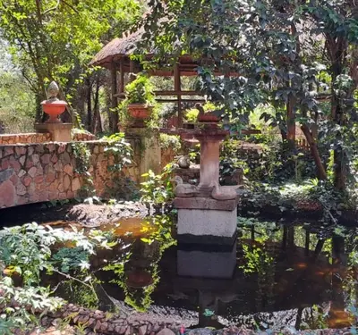 a garden with a water fountain and a gazebo at Duck and Dine in Pretoria