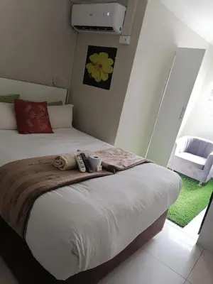 a bedroom with a bed with a remote control on it at Tshilidzi Guest House in Pretoria