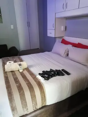 a bed with three remote controls on top of it at Tshilidzi Guest House in Pretoria