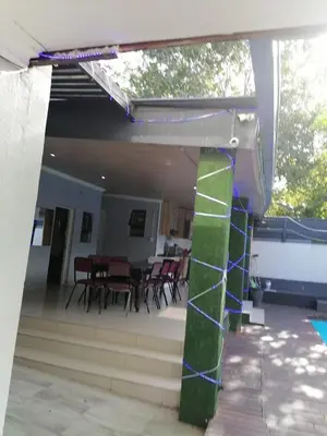 a view of a patio with chairs and a table at Tshilidzi Guest House in Pretoria
