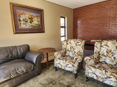 a living room with two chairs and a couch at Lloyds - 6 in Ermelo