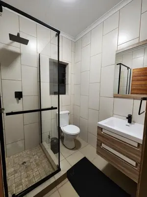 a bathroom with a shower and a toilet and a sink at Lloyds - 6 in Ermelo
