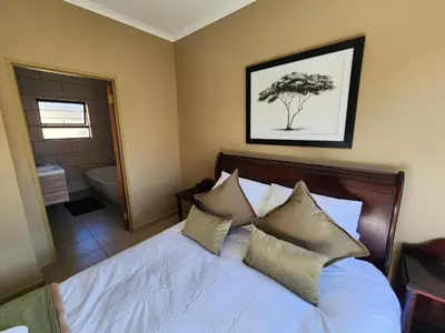 a bedroom with a bed with a tree on it at Lloyds - 6 in Ermelo