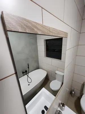 a bathroom with a tub and a toilet and a sink at Lloyds - 6 in Ermelo