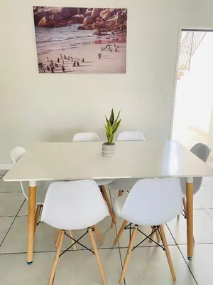 a white table with white chairs and a painting on the wall at Joy Apartment@The Blyde in Pretoria