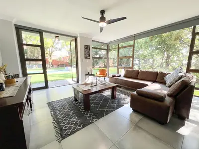 a living room with a couch and a table at Afrique134 Baobab Tree Private Family Garden Suite in Pretoria