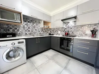 a kitchen with a washer and a washing machine at Afrique134 Baobab Tree Private Family Garden Suite in Pretoria