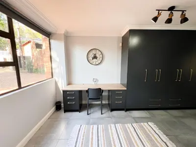 a home office with a desk and a window at Afrique134 Baobab Tree Private Family Garden Suite in Pretoria