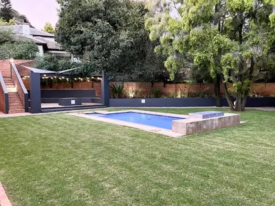 a backyard with a swimming pool in the grass at Afrique134 Baobab Tree Private Family Garden Suite in Pretoria