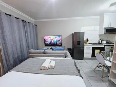 a living room with two beds and a kitchen at Quantum Heights - Studio Apartment - 2 nights minimum booking in Fourways