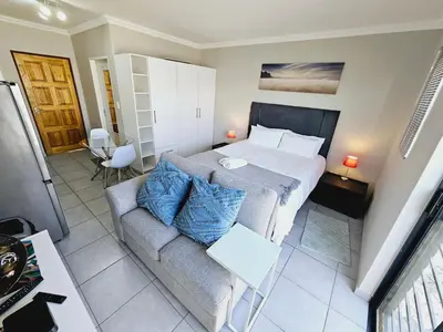 a small bedroom with a bed and a couch at Quantum Heights - Studio Apartment - 2 nights minimum booking in Fourways