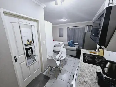 a small living room with a table and a couch at Quantum Heights - Studio Apartment - 2 nights minimum booking in Fourways