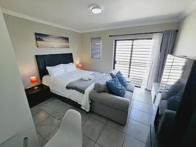 a bedroom with a bed and a couch at Quantum Heights - Studio Apartment - 2 nights minimum booking in Fourways