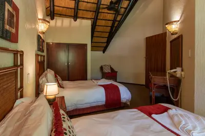 a hotel room with two beds and a desk at Kruger Park Lodge Unit No. 265 in Hazyview