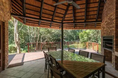 a patio with a table and chairs on a deck at Kruger Park Lodge Unit No. 265 in Hazyview