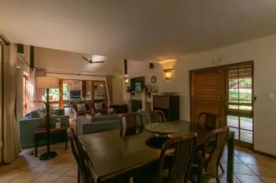 a dining room with a table and chairs and a living room at Kruger Park Lodge Unit No. 265 in Hazyview
