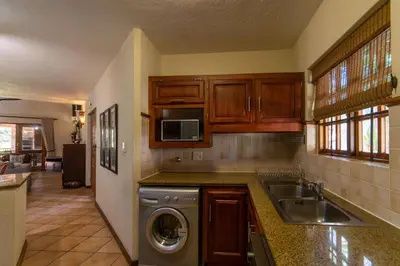 a kitchen with a sink and a washing machine at Kruger Park Lodge Unit No. 265 in Hazyview