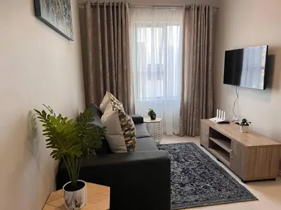 a living room with a black couch and a television at 93 on new unique and classy in Midrand